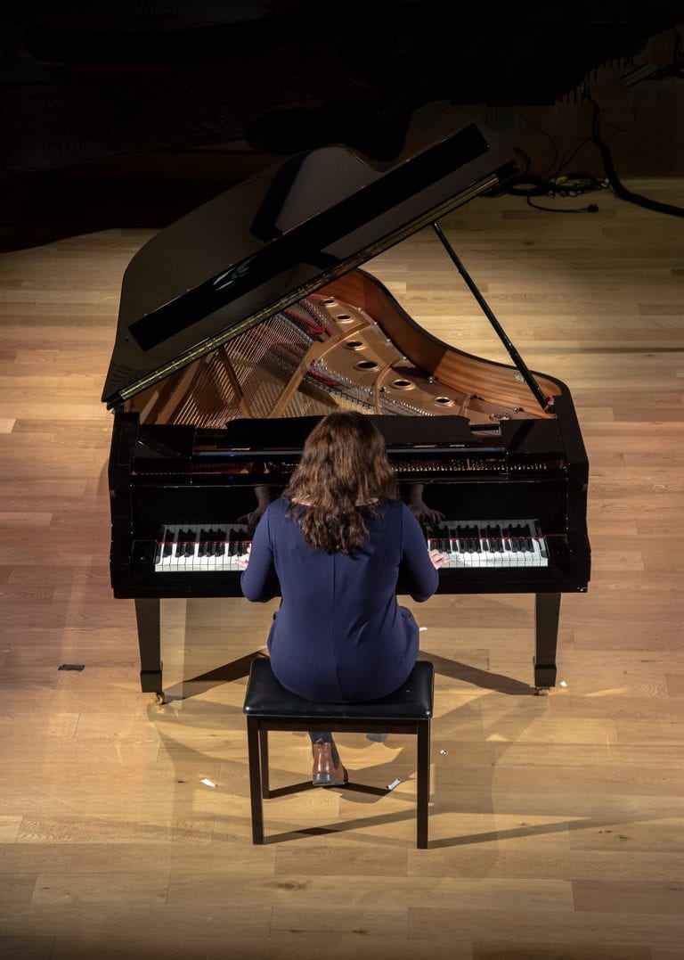 View from above as Ellie Ripley plays grand piano.