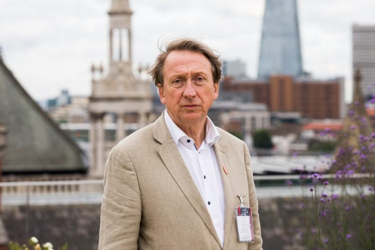 John Dovey stands with city in background.