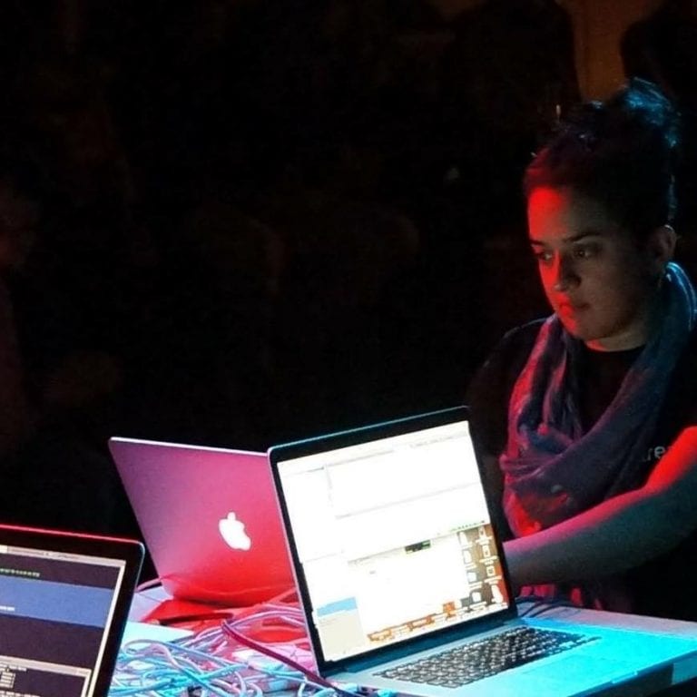 Norah Lorway working on macbook at desk.