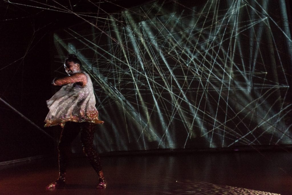 Woman dancing in front of lasers.