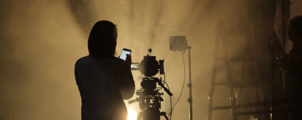 Silhouette of someone holding phone in front of camera.