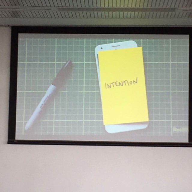 Smart phone with post-it note over it with the word "intention" written on it