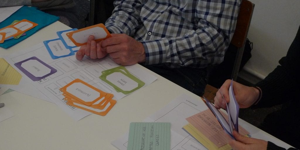 Close up of hands flicking through colourful record cards.