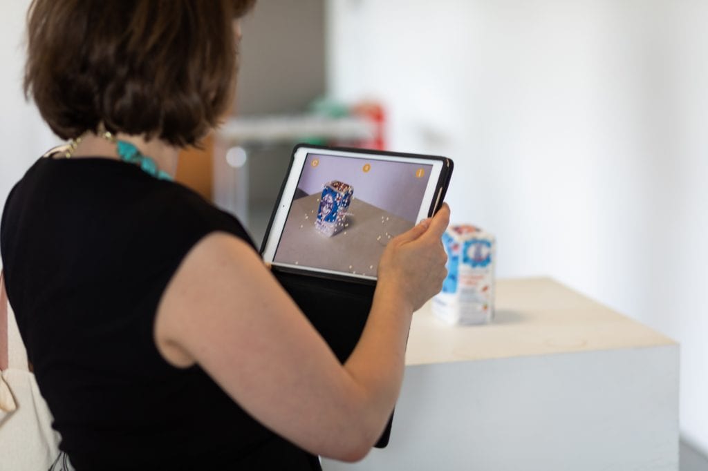 Women views bag of sugar through a tablet and circles show on her screen.