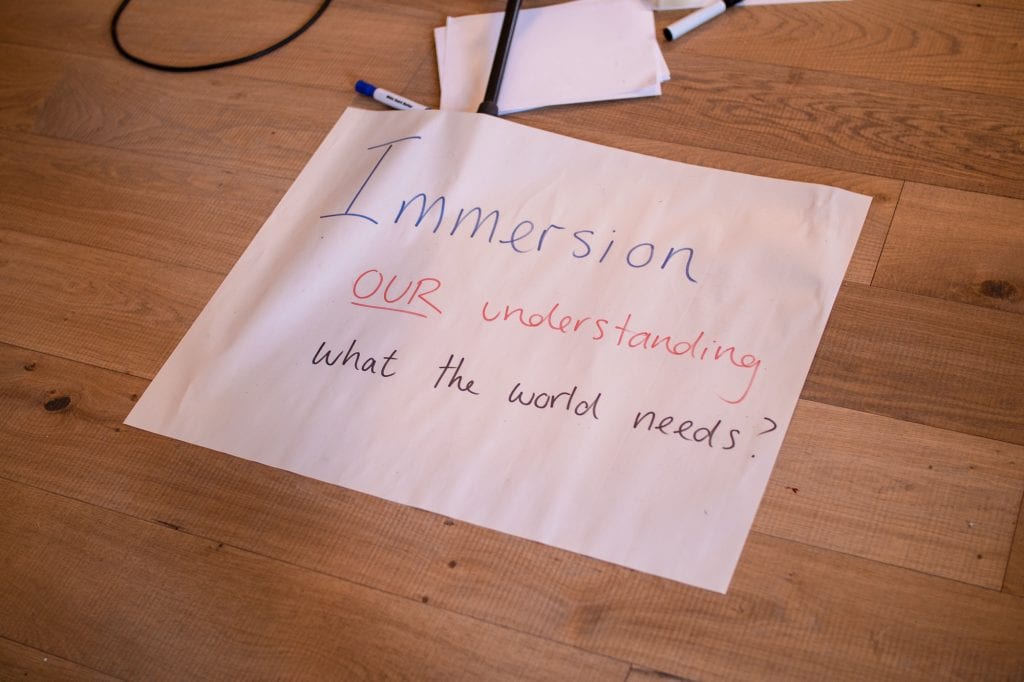 Piece of paper with handwritten text saying "Immersion our understanding what the world needs?"