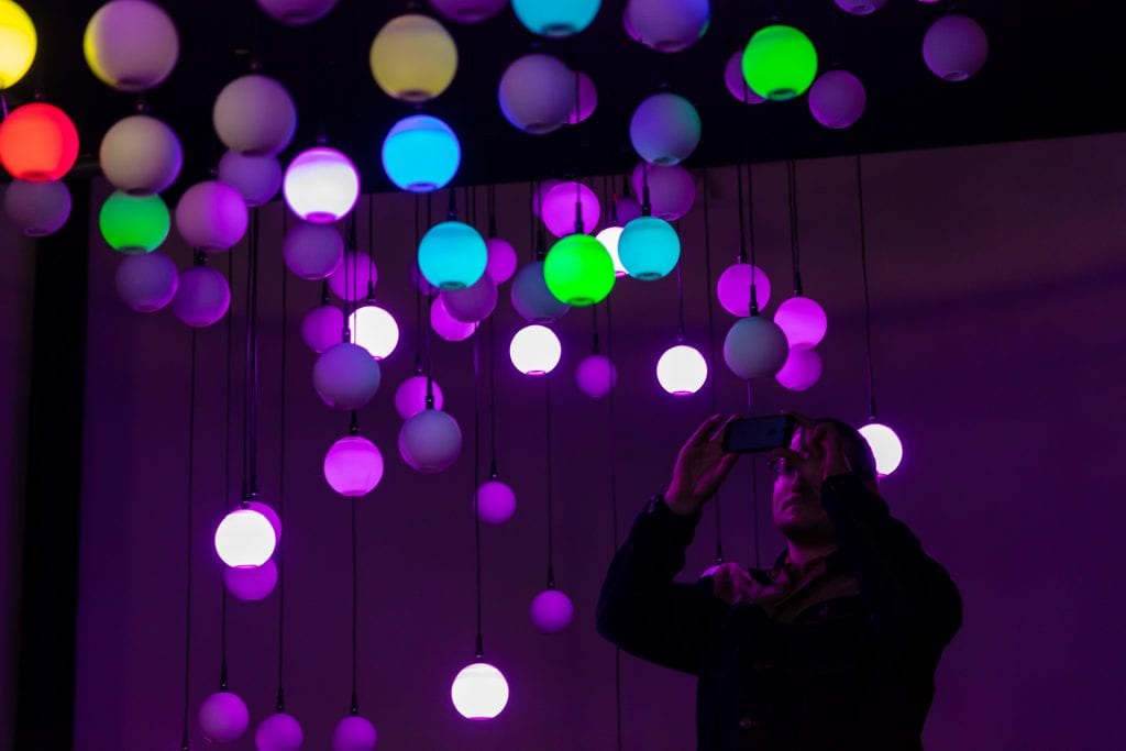 Man takes picture on phone of multicoloured light installation at Simple Things Festival 2019.