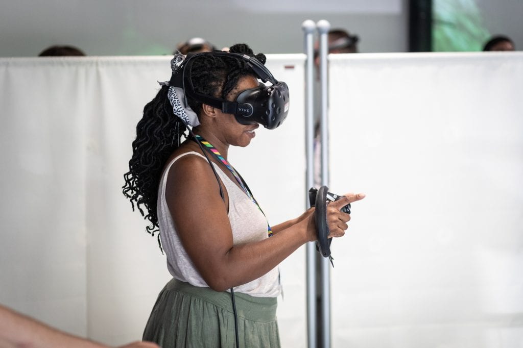 Woman in exhibition room wearing VR headset at SWCTN Showcase