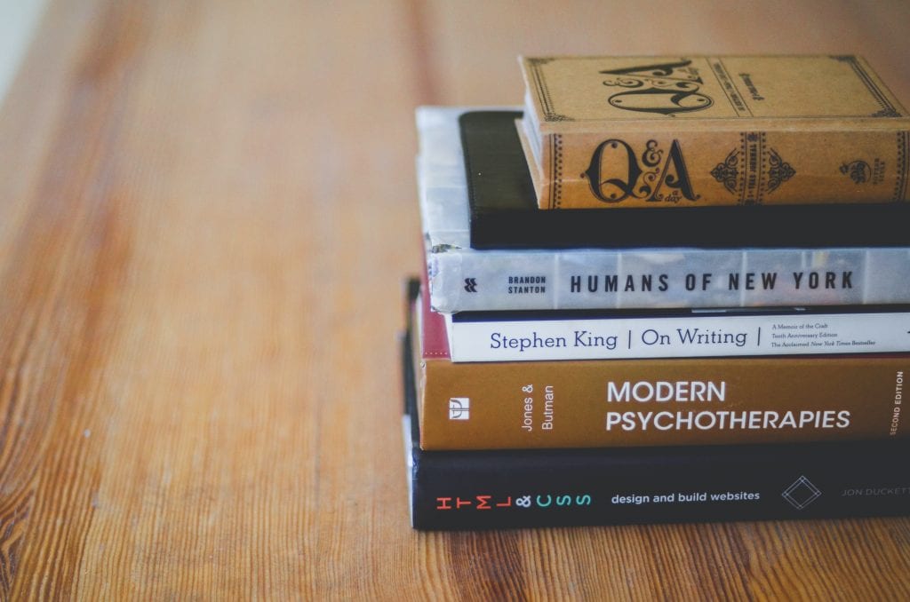 a stack of books on a wooden table